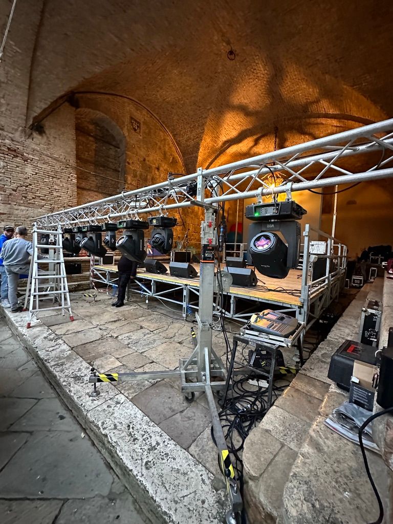 Montaggio di americana con teste mobili e palco modulare sotto una volta in mattoni